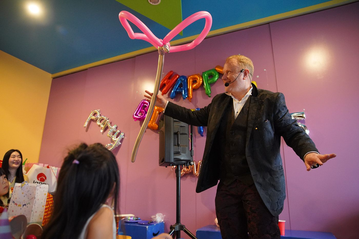 Jimmy Marvel presenting a giant pink balloon butterfly at a family event